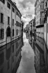 Tradycyjne budynki nad kanałem w starym włoskim mieście - 64880008