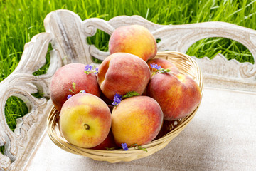 Basket of peaches on wooden tray. Summer garden party idea