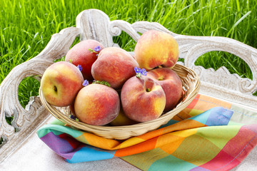 Basket of peaches on wooden tray. Summer garden party idea