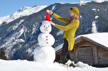 Girl decorating a snowman