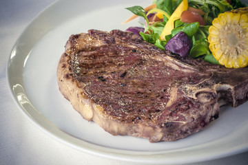 T-bone steak with grilled corn.