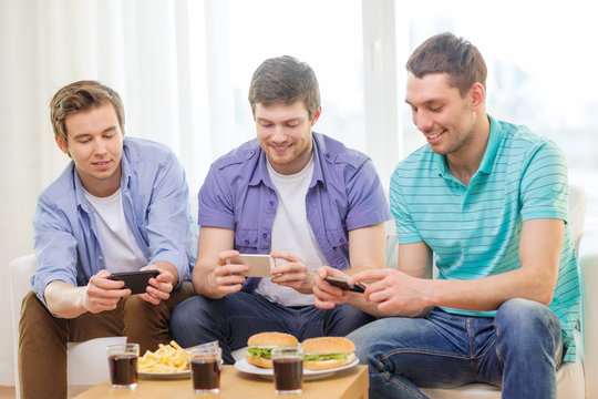 smiling friends taking picture of food at home