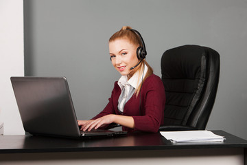 Portrait of smiling beautiful young support phone operator in
