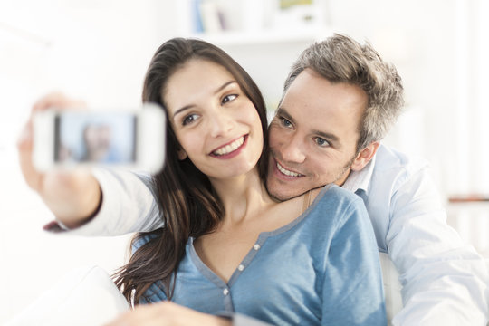 cheerful couple taking a selfie with a smartphone