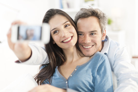 cheerful couple taking a selfie with a smartphone