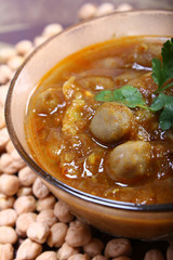 close up of indian spicy chana masala with raw chickpeas around