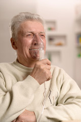 Elderly man making inhalation