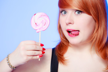 Sexy woman holding candy. Redhair girl eating sweet lollipop