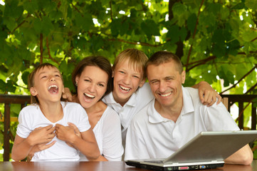 Family with laptop in nature