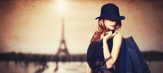 Redhead women with shopping bags on parisian background. - obrazy, fototapety, plakaty