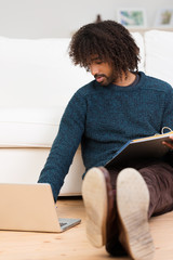 mann mit laptop und aktenordner zu hause