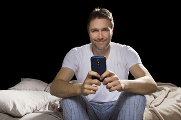 man in bedroom using cell phone late at night