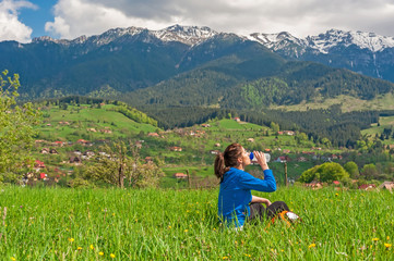 Fototapeta na wymiar Young woman resting on hill and amazing background