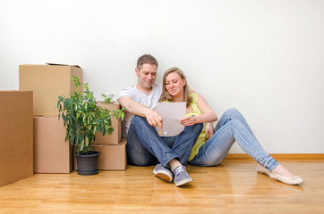 New home concept. Happy family sitting near boxes.