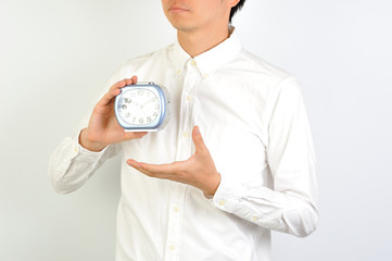 目覚まし時計を持っている男性