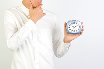 目覚まし時計を持っている男性