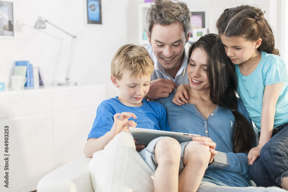 Wall mural family playing together on a digital tablet