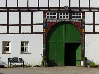 Grünes Tor eines traditionellen Bauernhaus imm Sonnenschein in Oetenhausen und Helpup bei Oerlinghausen und Detmold am Hermannsweg im Teutoburger Wald in Ostwestfalen-Lippe © Martin Debus