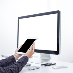 Hand holding tablet with computer background
