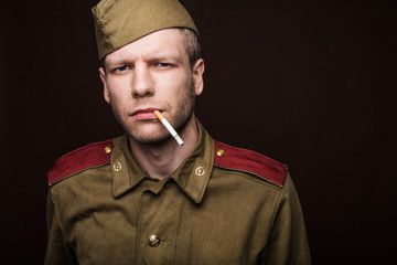 Russian soldier smoking cigarette and looks at something