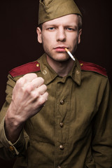 Russian soldier smoking cigarette and threaten with a fist