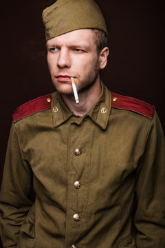Russian soldier smoking cigarette and looks at something