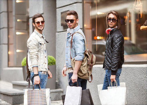 fashion young guys go shopping with many colored shopping bags