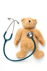 Bear doll and stethoscope on a white background