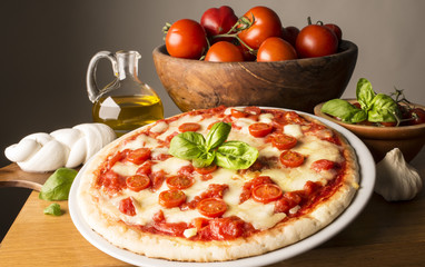 Pizza with ingredients on the wooden table