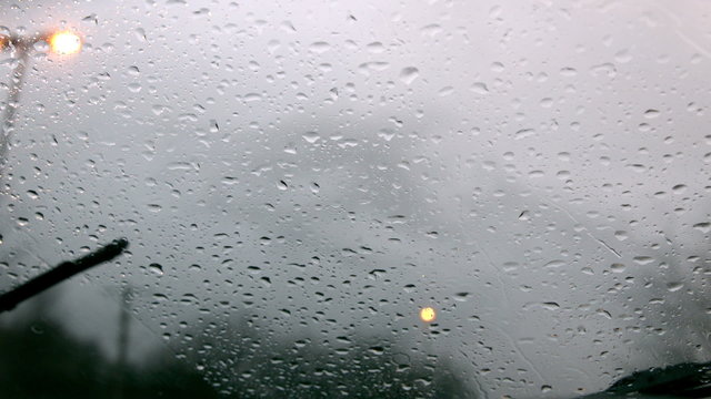 Windscreen wiper wiping rain away from car window