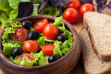 Salad on wooden plate.
