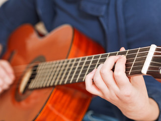 Obraz premium woman plays on classical acoustic guitar