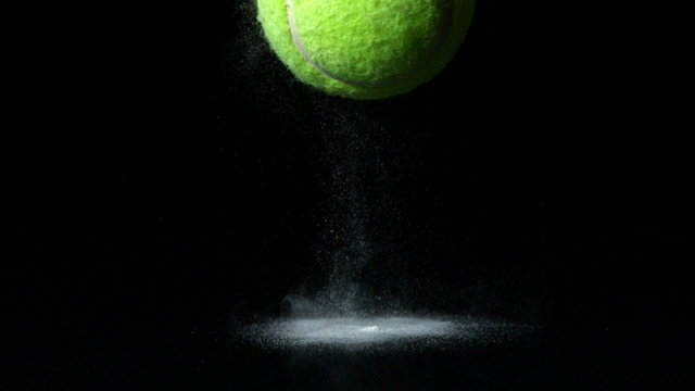 Tennis ball falling on black background