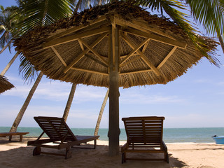 sun loungeres and  Umbrellas against  blue sea at sun day Mui Ne