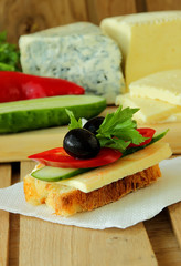 Sandwich with cheese, vegetables and olive.
