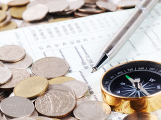  Pen and compass on bank account book with coins background