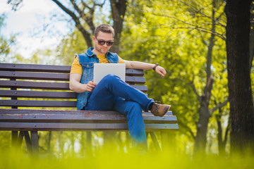 young man on the bench with a laptop