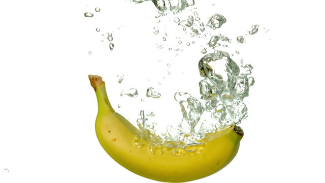 Banana plunging into water on white background