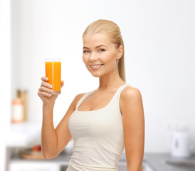 smiling woman holding glass of orange juice