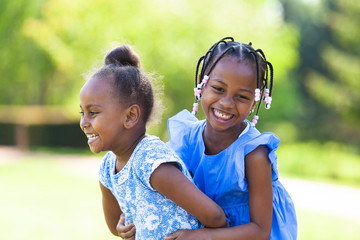 Outdoor  portrait of a cute young black sisters - African people - 64921688