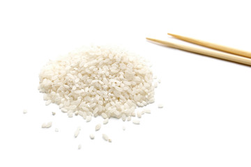 White dry uncooked grain rice with wooden pairs of chopsticks