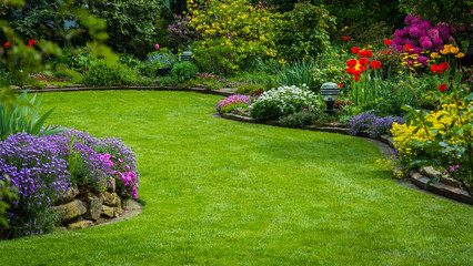 Fototapeta premium Widok na ogród z trawnikiem i sadzeniem