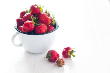 strawberries in white enamel mug