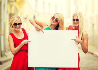 three happy blonde women with blank white board