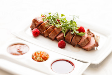 grilled duck breast covered with sweet red fruit sauce