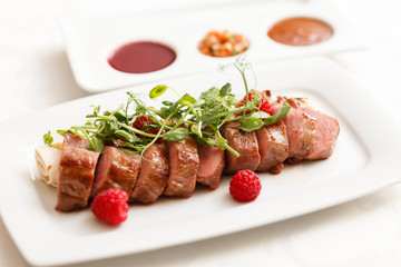 grilled duck breast covered with sweet red fruit sauce