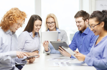 Fototapeta premium smiling team with table pc and papers working
