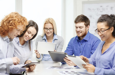 smiling team with table pc and papers working