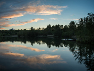 Summer vibrant sunset reflected in calm lake waters