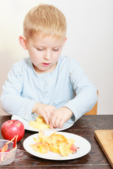 childhood. Boy child kid eating peeled apple fruit. At home.